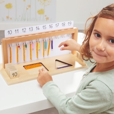 Menina a usar brinquedo educativo de madeira com contas coloridas e números de 10 a 19