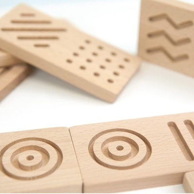 Blocos de madeira claros com padrões geométricos gravados