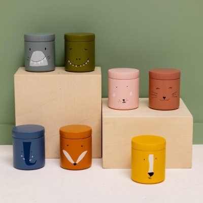 Frascos cilíndricos coloridos com desenhos de animais, em blocos de madeira, fundo verde