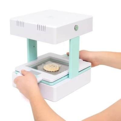 Dispositivo branco e verde claro com objeto amarelo dentro