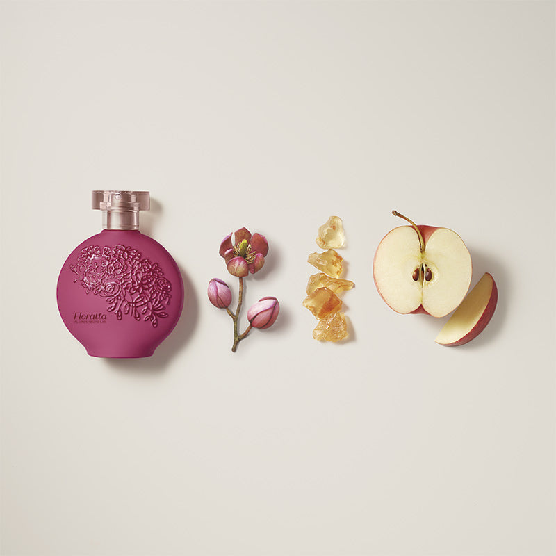 Floratta Flores Secretas Eau de Toillete 75ml Perfume vinho, flor rosa, cristais âmbar e maçã cortada alinhados em fundo branco