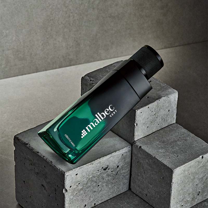 Frasco de perfume Malbec Vert verde sobre blocos de cimento cinzentos