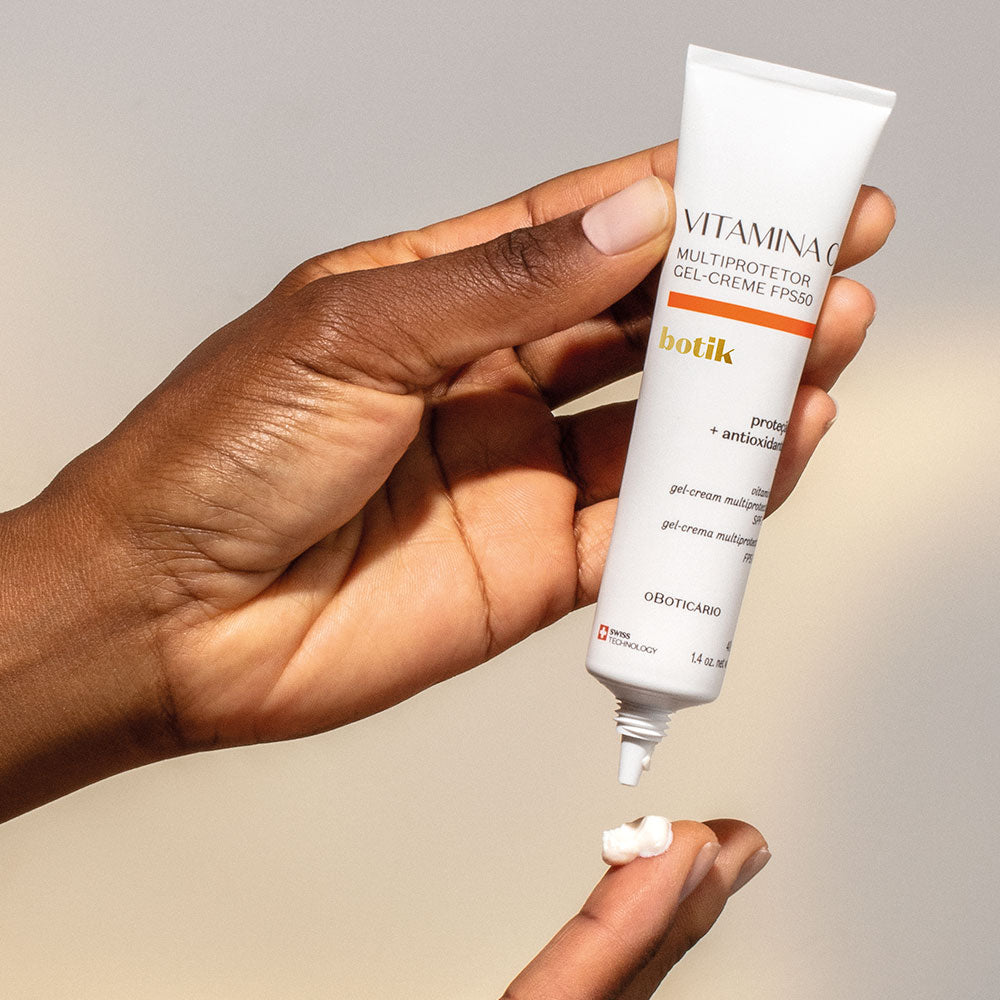 Botik Vitamina C Multiprotetor Gel Creme FPS50 40g Mãos a aplicar creme branco de tubo VITAMINA MULTIPROTETOR GEL-CREME FPS50 botik