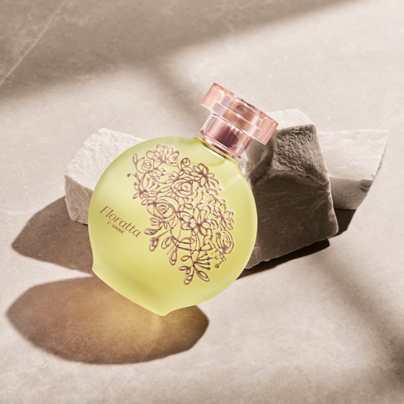 Floratta L'Amore Eau de Toilette 75ml Frasco de perfume Floratta verde fosco com tampa rosa sobre pedras claras