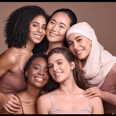 Cinco mulheres de diferentes etnias posam juntas com roupas neutras e uma usa hijab.