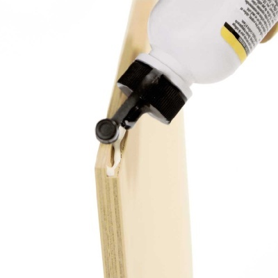 Garrafa branca com tampa preta em madeira clara sobre fundo branco