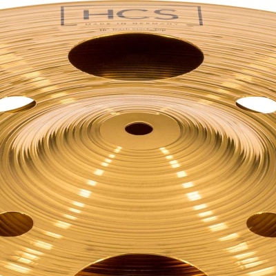 Prato de bateria de metal dourado com vários furos circulares e texto impresso