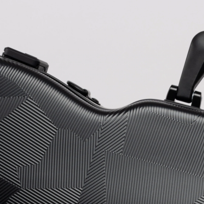 Mala de viagem rígida preta com padrão geométrico em relevo e pega preta