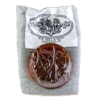 Sabonete castanho translúcido sobre espuma cinza com etiqueta branca W.E. Hill & Sons