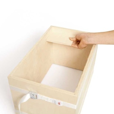 Caixa de armazenamento em madeira clara com tampa móvel, mão a levantar tampa