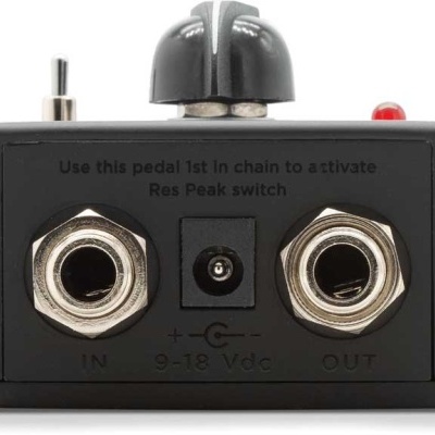 Pedal de efeito preto com conectores jack e texto instrucional na traseira