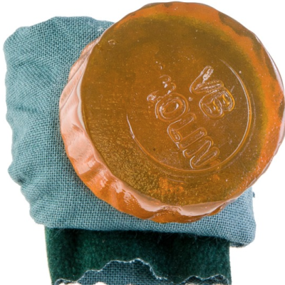 Sabonete âmbar com inscrição sobre tecido azul