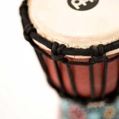 Tambor de madeira com pele esticada e base colorida com padrões florais