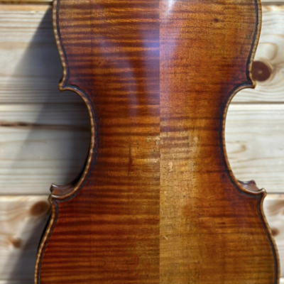 Parte traseira de um violino em madeira castanha com textura natural