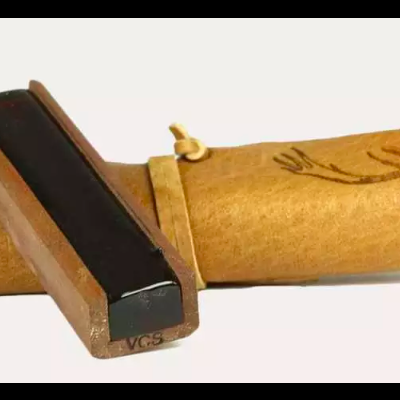 Objeto de madeira claro com tampa arredondada e peça retangular preta encaixada