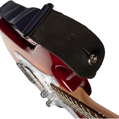 Correia preta em couro e tecido ligada a guitarra elétrica vermelha