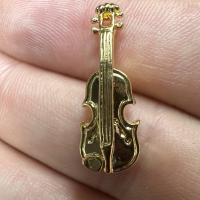Pequena peça decorativa dourada em forma de violino