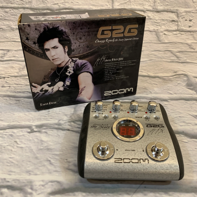Pedal de efeitos para guitarra Zoom G2G George Lynch Mr. Scary Signature Edition com caixa e pedal visíveis
