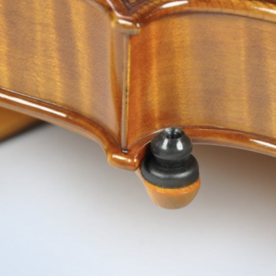 Detalhe da parte inferior de um violino em madeira com botão preto e marrom