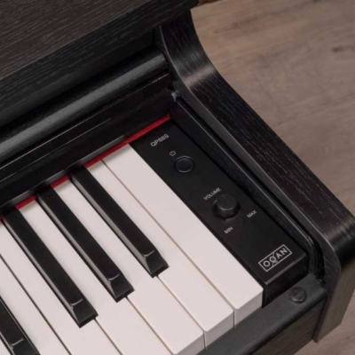 Teclado digital preto com teclas brancas e pretas e controlos de volume