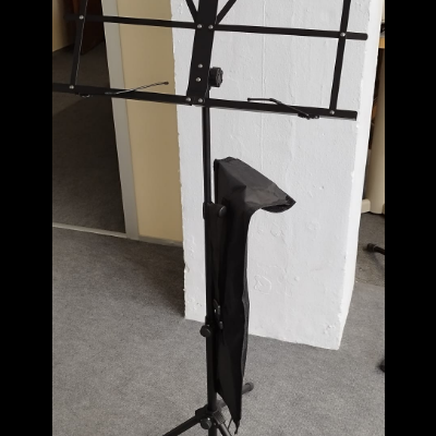 Estante de música metálica preta com tripé e bolsa pendurada