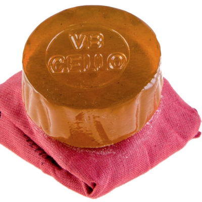 Sabonete castanho redondo com texto VE CEILO sobre tecido rosa