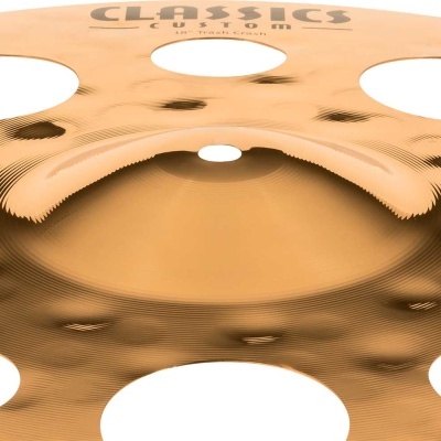 Prato musical metálico dourado com orifícios circulares e gravação de texto