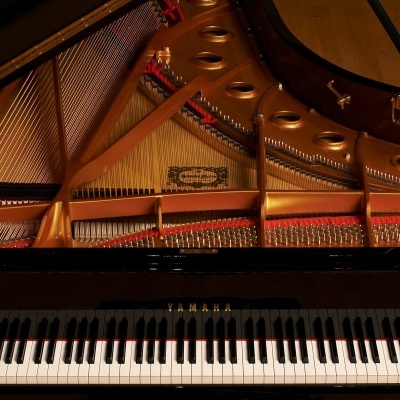 Piano de cauda Yamaha preto com teclado e interior dourado exposto