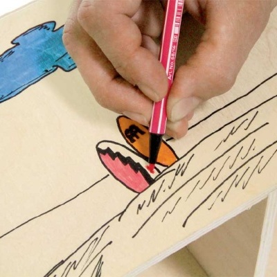 Mão a colorir desenho de asa de borboleta com lápis de cor vermelho sobre papel com nuvens azuis e linhas pretas