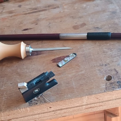 ferramentas para manutenção de violino sobre mesa de madeira