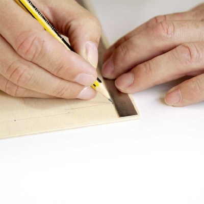 Mãos a desenhar com lápis numa folha clara com seção pintada castanho