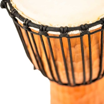 Tambor djembé com pele branca, cordas pretas e corpo de madeira entalhada