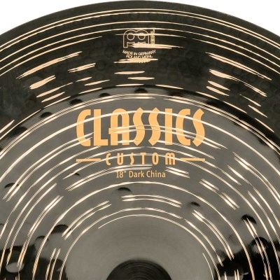 Prato de bateria escuro com padrão texturizado e texto amarelo