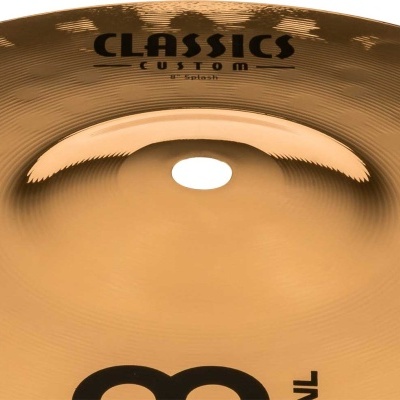 Prato de bateria metálico dourado com texto CLASSICS CUSTOM splash e logotipo MEINL