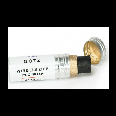 Sabonete em stick preto em embalagem cilíndrica metálica prateada com rótulo branco