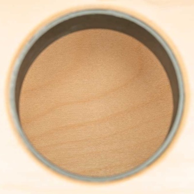 Orifício circular em madeira clara com bordas cinzentas e padrão natural interno