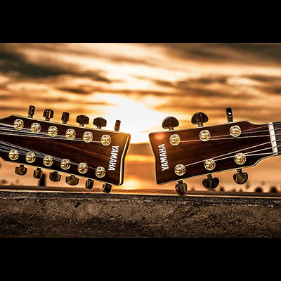 Cabeças de duas guitarras acústicas Yamaha em madeira castanha com tarraxas douradas ao pôr do sol