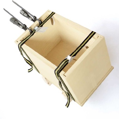 Caixa de madeira clara com cabos metálicos e tiras pretas e amarelas