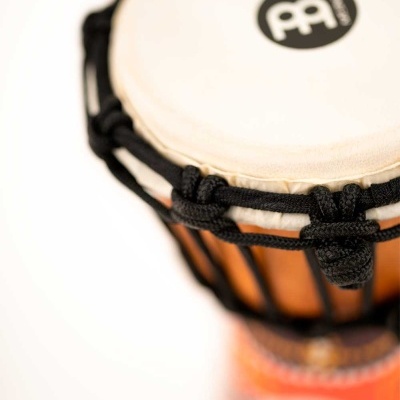 Tambor de mão de pele branca com corpo de madeira e cordas pretas