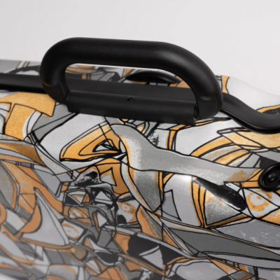 Mala de viagem rígida com padrão geométrico cinza, preto e amarelo e pega preta