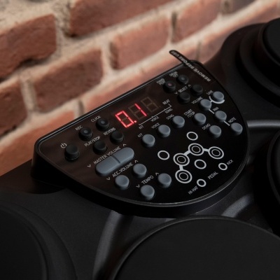 Bateria eletrónica preta com painel de controle e visor digital