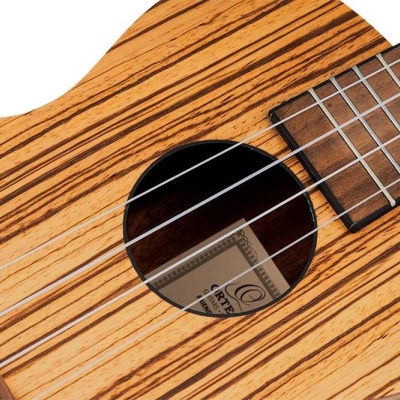 Ukulele de madeira clara com cordas brancas e braço de madeira escura