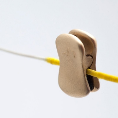 Prendedor de roupa metálico dourado em fio amarelo