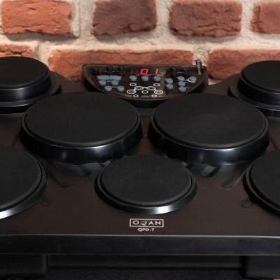 Bateria eletrónica preta com 7 pads e painel de controlo digital