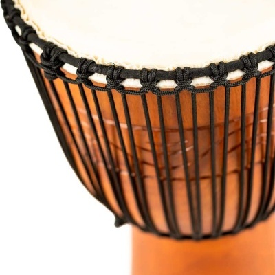 Tambor djembe com pele branca e cordas pretas sobre corpo de madeira