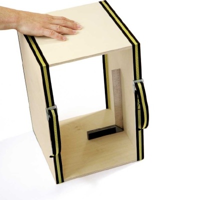 Estrutura de madeira com cintas pretas e amarelas com mão sobre a parte superior