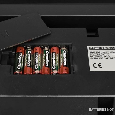Pilhas AA Camelion em teclado eletrônico com etiqueta e aviso de pilhas não incluídas