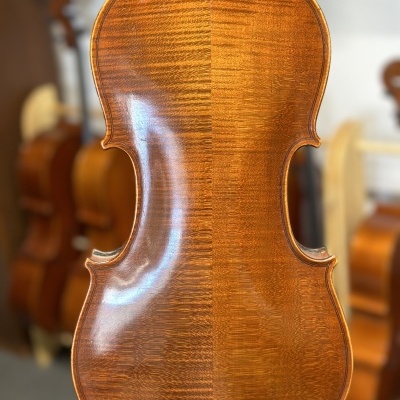 Costas de violino em madeira castanho-avermelhada polida com padrão ondulado