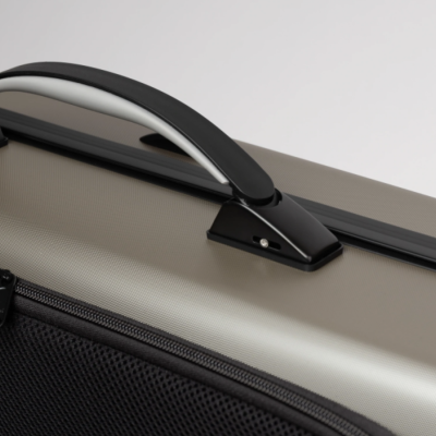 Mala de viagem rígida cinza com pega preta e detalhes em cinza