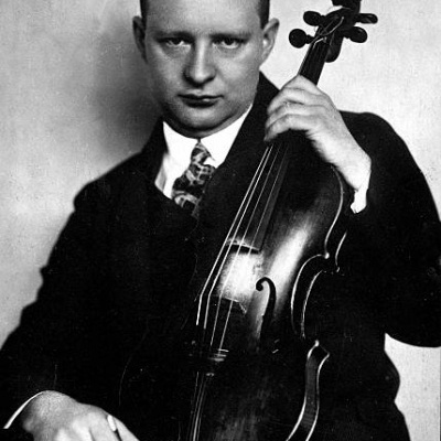 Homem de fato a segurar um violino de madeira escura e um arco